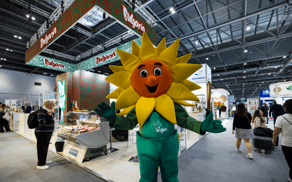 A Happy Vegan Sunflower Exhibition mascot greets visitors at an event